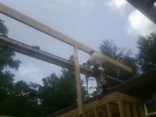 Carpenter setting a ridge beam over a new addition frame — Ice Dam Removal by Roofing Brothers in Exton
