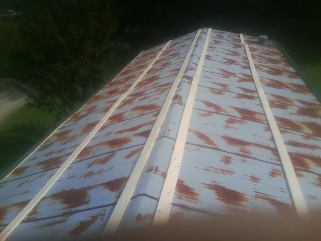 Rusted metal roof panels with new wood purlins before replacement — Storm Damage Roof Repair in Exton by Roofing Brothers