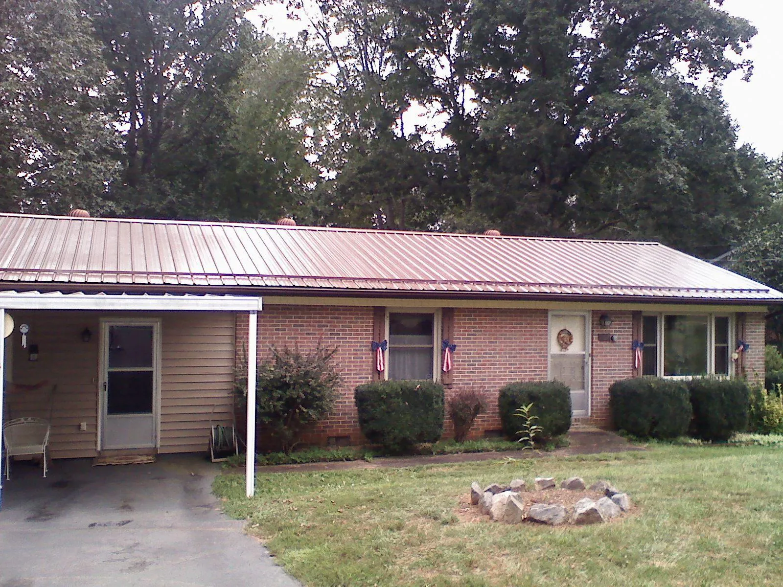 Bronze metal roof and carport on a brick ranch home — Roof Repair work by our crew in Exton